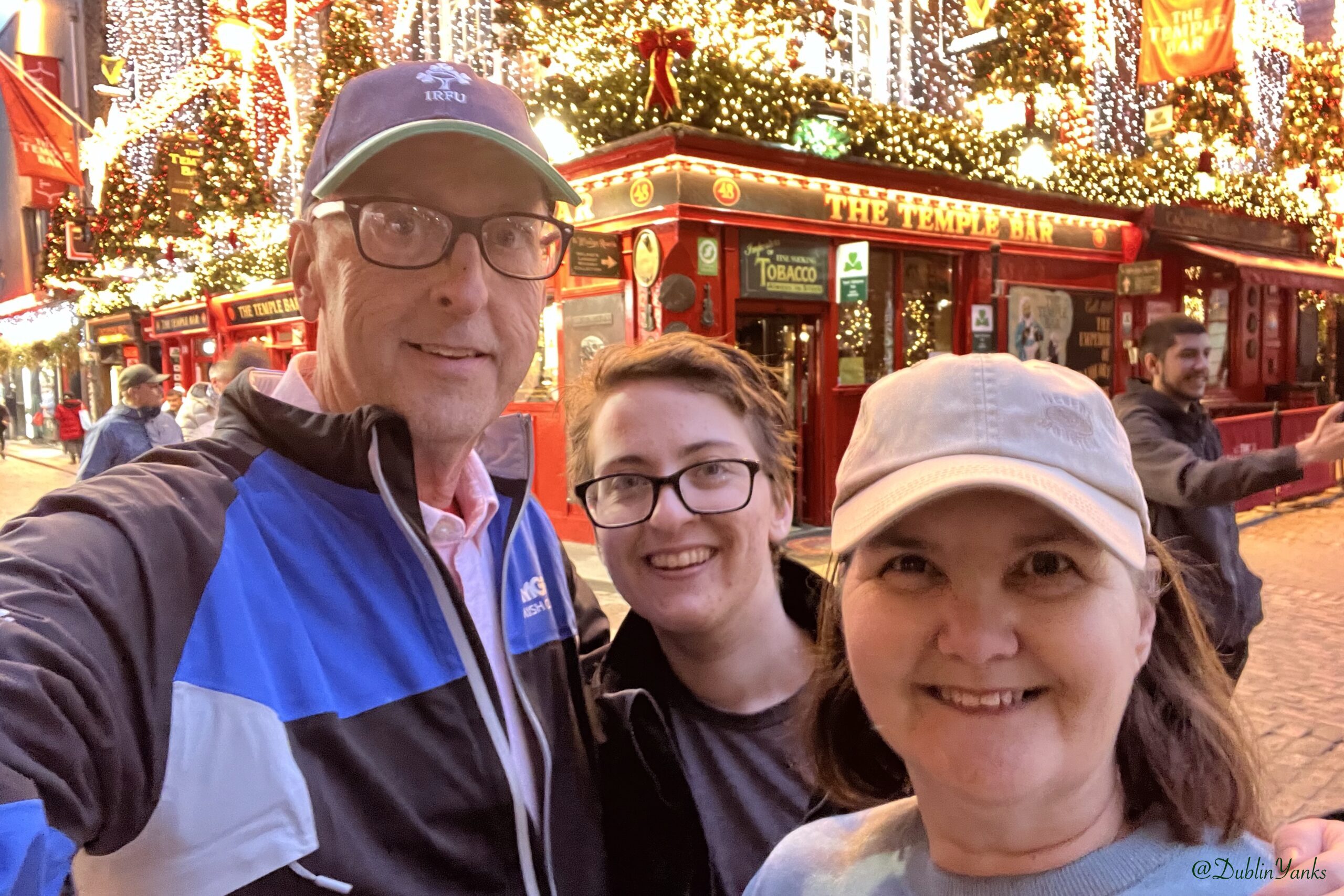 Group smiling in front of Temple Bar with Christmas lights